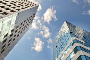 Structural glass wall reflecting blue sky. Abstract modern architecture fragment. photo