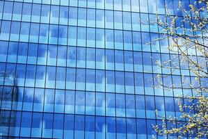 Structural glass wall reflecting blue sky. Abstract modern architecture fragment. photo