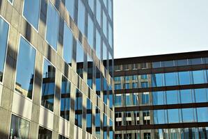 Structural glass wall reflecting blue sky. Abstract modern architecture fragment. photo