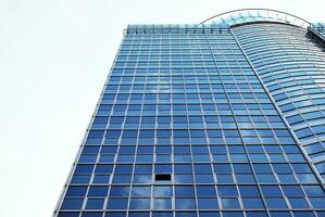 Structural glass wall reflecting blue sky. Abstract modern architecture fragment. photo