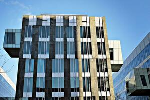 Structural glass wall reflecting blue sky. Abstract modern architecture fragment. photo