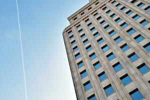 Structural glass wall reflecting blue sky. Abstract modern architecture fragment. photo