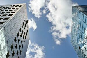 Structural glass wall reflecting blue sky. Abstract modern architecture fragment. photo