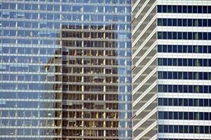 Structural glass wall reflecting blue sky. Abstract modern architecture fragment. photo