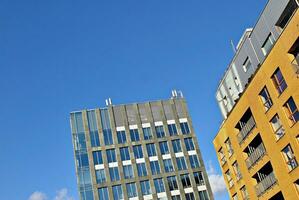 Structural glass wall reflecting blue sky. Abstract modern architecture fragment. photo