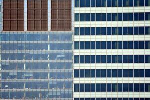 Structural glass wall reflecting blue sky. Abstract modern architecture fragment. photo