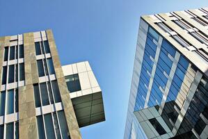 Structural glass wall reflecting blue sky. Abstract modern architecture fragment. photo