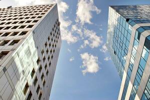 Structural glass wall reflecting blue sky. Abstract modern architecture fragment. photo