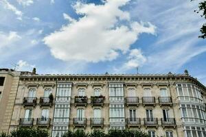 a building with balconies and a sky with clouds photo