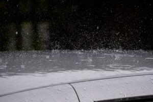 un coche es cubierto en lluvia foto