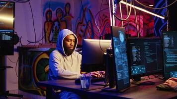 Close up shot of african american man hacking systems, stealing credit card numbers and manipulating banking systems for his own personal gain. Zoom in on evil hacker running code in basement video