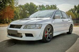 White car on a street background. Modern city sport car with spoiler wallpaper photo