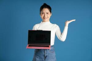 Portrait of beautiful asian woman posing on blue background photo