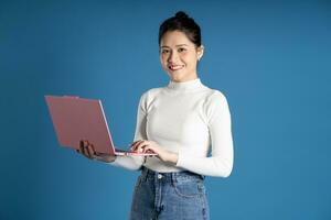 Portrait of beautiful asian woman posing on blue background photo