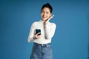 Portrait of beautiful asian woman posing on blue background photo