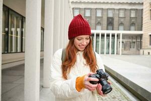 hermosa cabeza lectora chica, fotógrafo con profesional cámara toma imágenes al aire libre, caminando alrededor ciudad y tomando fotos, Turismo foto