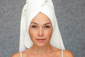 Portrait of caucasian middle aged woman of 40s with towel on head looking at camera photo