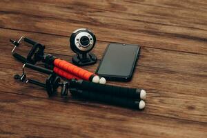 Two manual tripod monopods for a phone or a small camera on a wooden table. photo