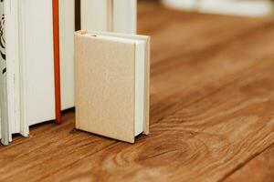 A stack of books stand on the tables, stacked in the frame, next to small mini books. photo