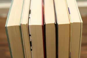 A stack of books stand on the tables, stacked in the frame photo