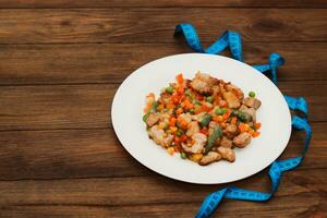 Stewed vegetables with meat, vegetables carrots, peas, beans in a plate. photo