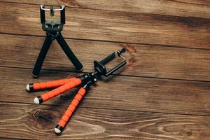 Two manual tripod monopods for a phone or a small camera on a wooden table photo