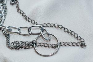 Stylish silver chain jewelry on the neck on a silk shiny background. photo