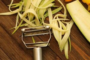 Chopped vegetables, carrots, peppers, zucchini on a vegetable peeler. photo