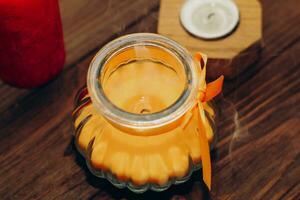 Orange aroma candle in a figured candlestick with a bow. photo