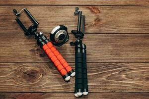 Two manual tripod monopods for a phone or a small camera on a wooden table. photo