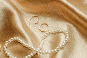 Women's jewelry, gold chain, trendy jewelry on a silk background. photo