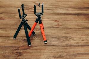 Two manual tripod monopods for a phone or a small camera on a wooden table photo