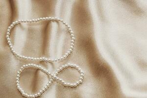 Pearl bijouterie beads on silk texture background. photo