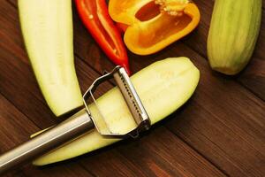 Chopped vegetables, carrots, peppers, zucchini on a vegetable peeler. photo