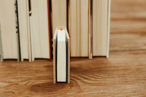 A stack of books stand on the tables, stacked in the frame, next to small mini books. photo