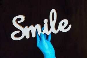 The inscription Smile in the hands of a doctor surgeon dentist photo