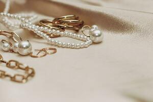 Women's jewelry, gold chain, trendy jewelry on a silk background. photo