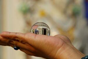 cristal pelota en Derecha dama mano y difuminar antecedentes. foto