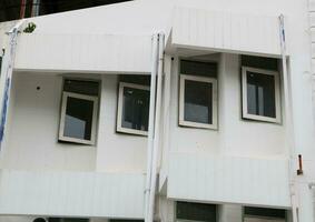 Closed glass window on concrete wall of white painted building. photo