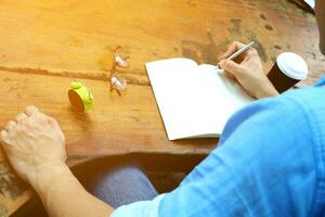 a person sitting at a table with a notebook and a watch photo