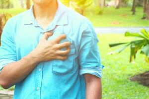 a man is holding his chest in the grass photo