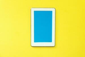 a white tablet computer on a yellow background photo