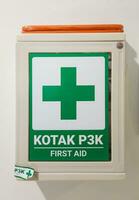 a close up photo of first aid box mounted on white wall
