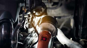 Abstract of bright light from a flashlight and a dark picture inside the car's engine compartment. photo