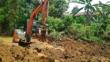 Kuaro Kalimantan Timur, Indonesia 29 November 2023. Excavator heavy equipment is digging irrigation canals photo