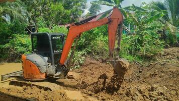 Kuaro Kalimantan Timur, Indonesia 29 November 2023. Excavator heavy equipment is digging irrigation canals photo