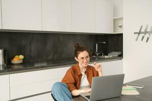 retrato de joven persona de libre dedicación, mujer tutor trabajando desde hogar, dando en línea lecciones estudiante conecta a remoto clase desde computadora y mirando a pantalla foto