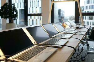 Row of laptops being prepared and set up for new employees in a company photo