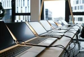 Row of laptops being prepared and set up for new employees in a company photo