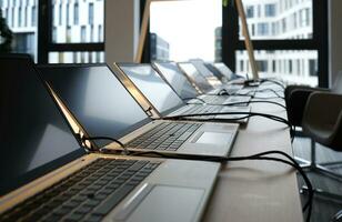 Row of laptops being prepared and set up for new employees in a company photo